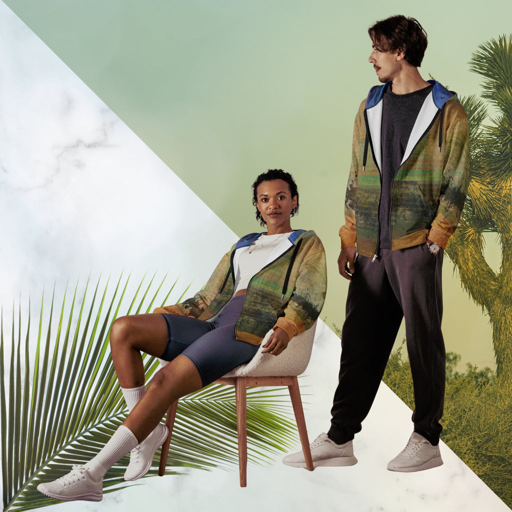 Multicolored primarily orange all over print zip hoodie depicting a long distance view of trees and power lines with vintage 90s style distortion abstract orange dot grids line patterns in shades of green and yellow black ink splotch lines and the background appearing as a painted canvas jungle plants and graphic lines overlayed on the sleeves