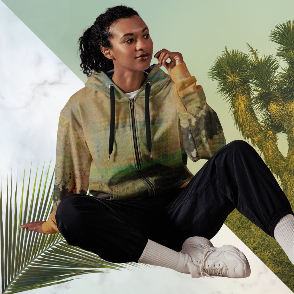 Multicolored primarily orange all over print zip hoodie depicting a long distance view of trees and power lines with vintage 90s style distortion abstract orange dot grids line patterns in shades of green and yellow black ink splotch lines and the background appearing as a painted canvas jungle plants and graphic lines overlayed on the sleeves