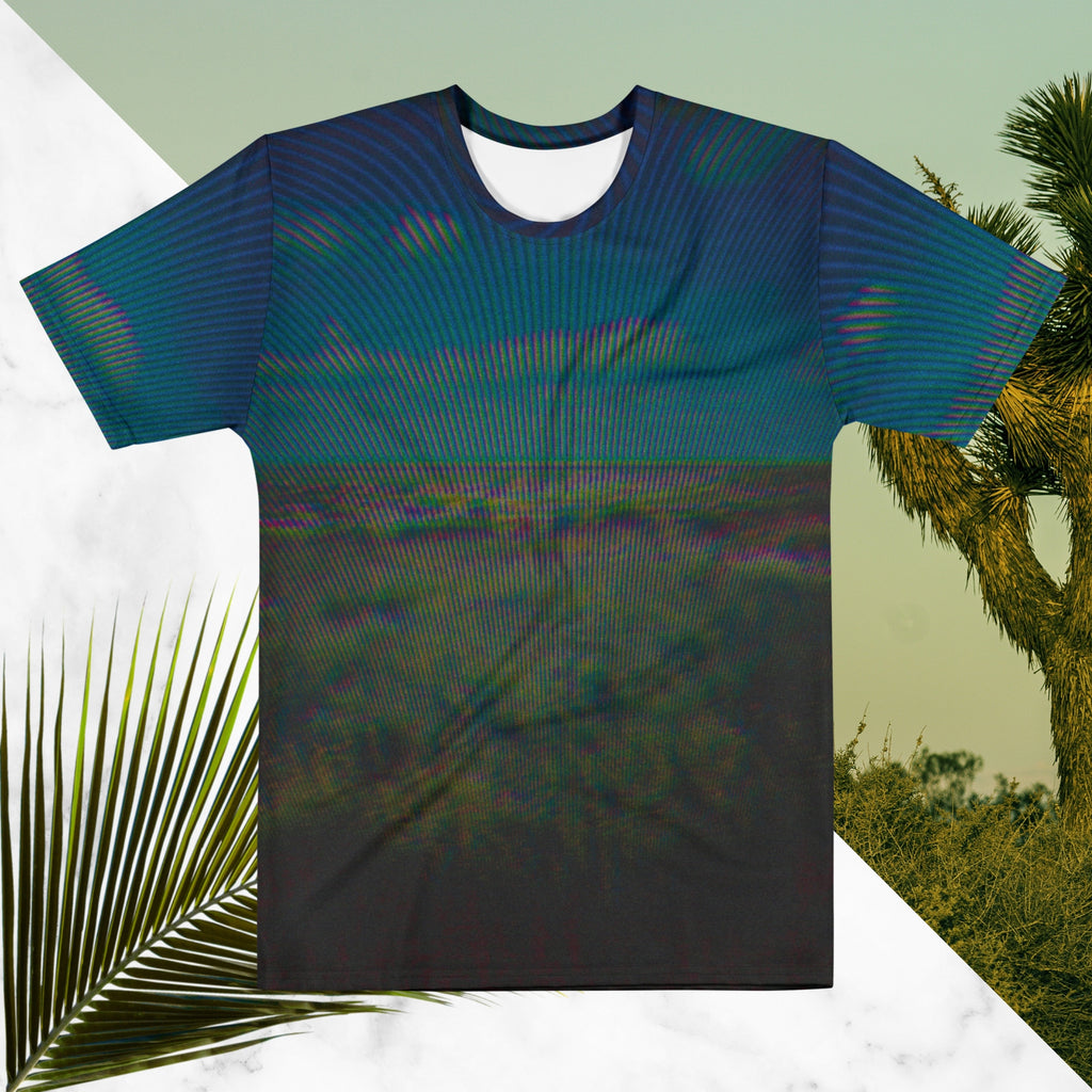 Full color all over print graphic tee shirt with image of a desert and green desert plants and blue sky with clouds above the horizon overlayed with rgb distortion and psychedelic lines graphics fanning outward towards the top
