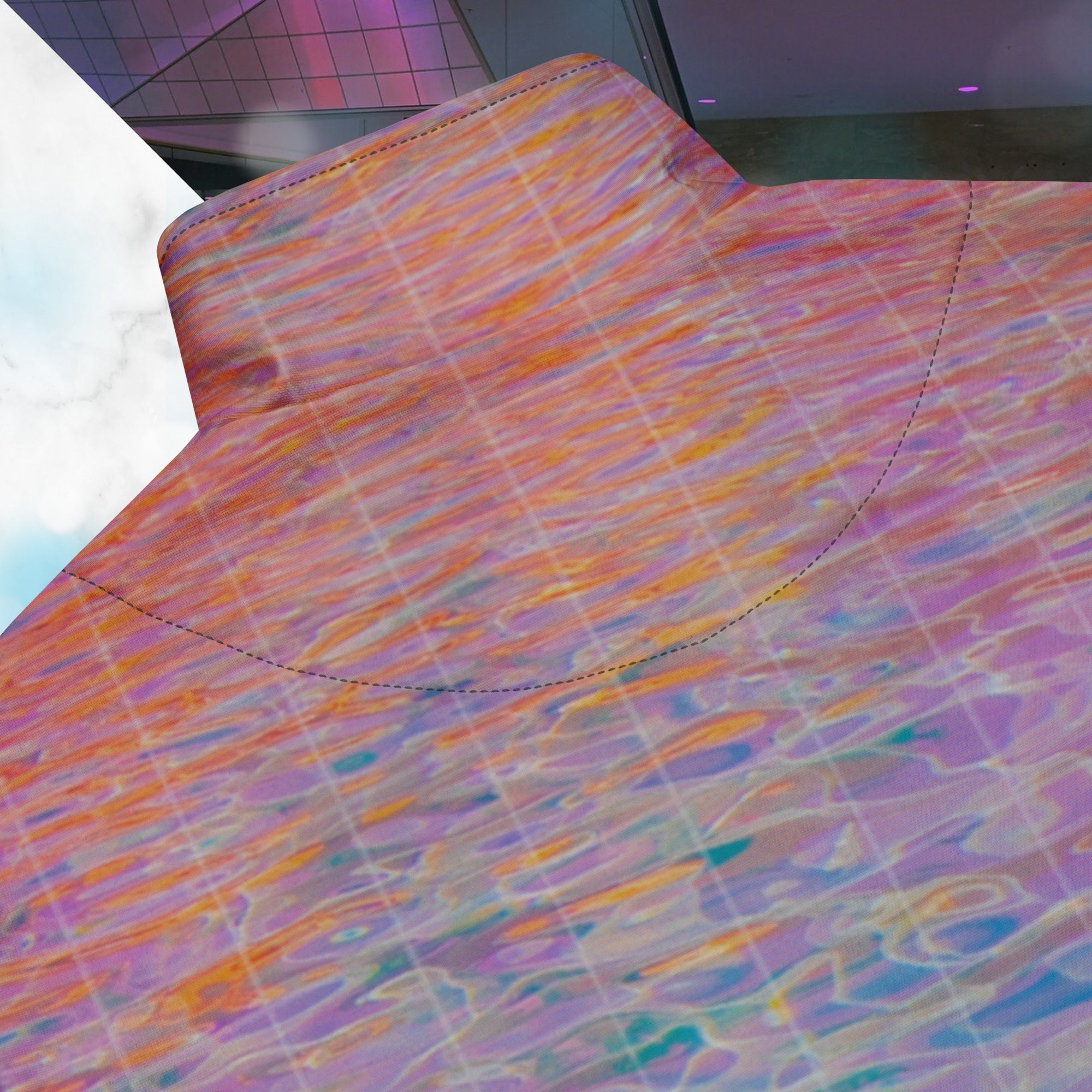 Closeup of back of collar and sitching on multicolored all over print track jacket depicting blue water reflecting the colors of the sunset in oranges and pinks intensifying towards the top overlayed with a transparent thin white grid with tropical plant silhouettes of tropical plants creating stripe effects on sleeves with Neon Pools vaporwave sun emblem on left chest area