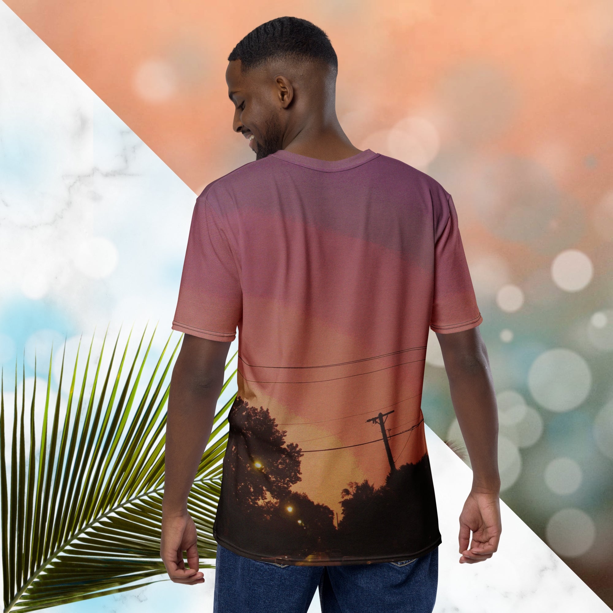 Multicolored all over print graphic t-shirt depicting a sunset with concentric layers of purple, red, orange and yellow with a foreground of trees, street lights, telephone lines and a city street with detailed vhs effects