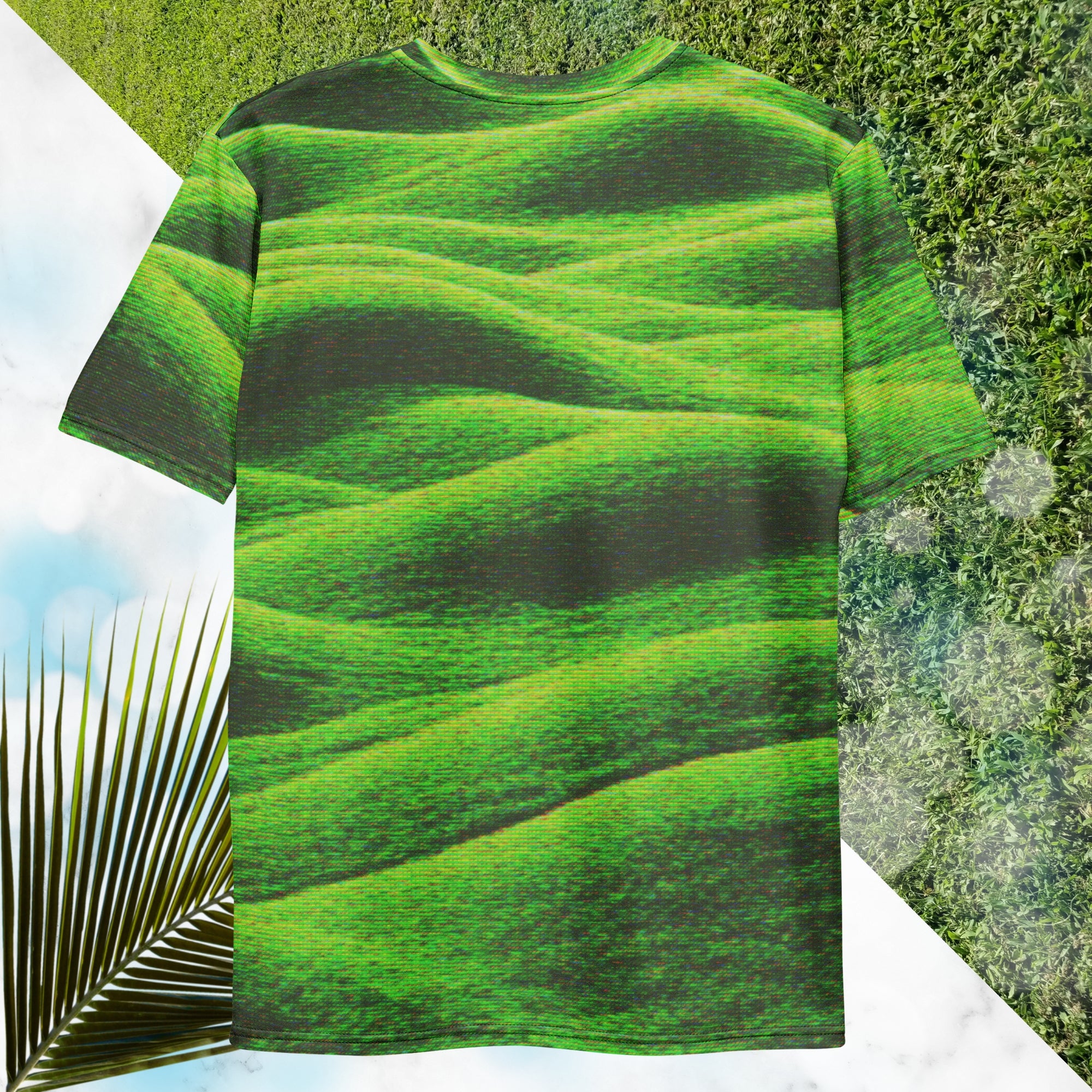 Green and black all over print graphic t-shirt depicting grass covered green rolling hills and their shadows overlayed with detailed v h s and retro t v distortion 