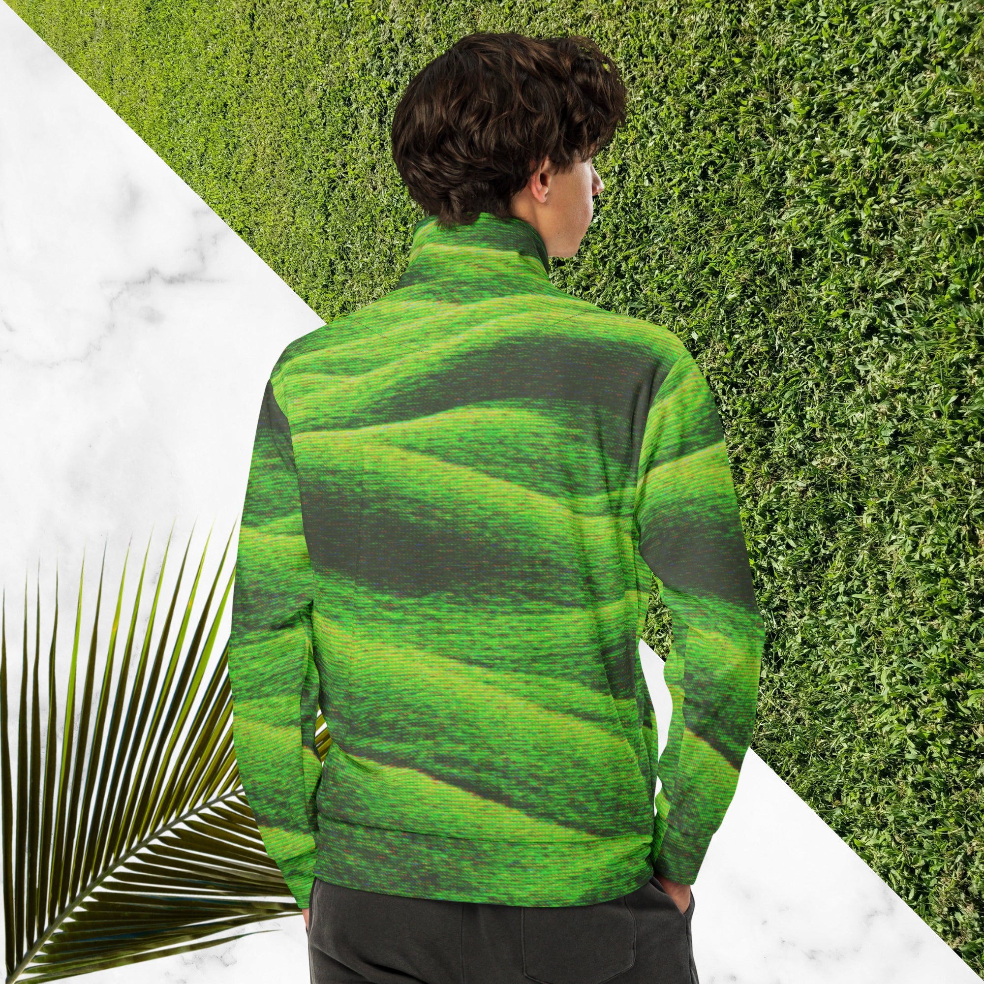 Primarily green and black full color all over print track jacket depicting grass covered green rolling hills and their shadows overlayed with detailed v h s and retro t v distortion with a green and blue Neon Pools vaporwave sun and waves emblem on the left chest
