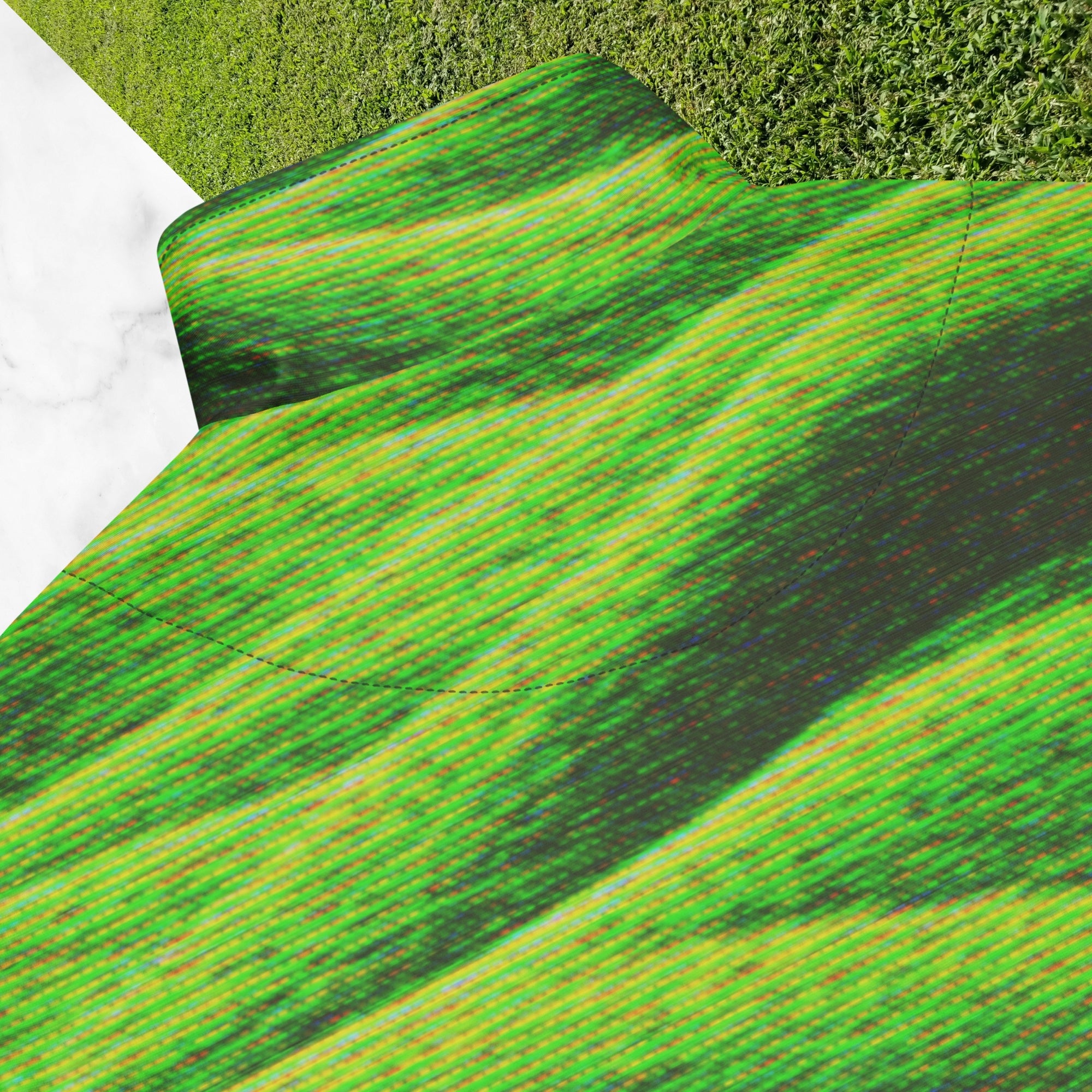 Closeup of back collar and stitching on primarily green and black full color all over print track jacket depicting grass covered green rolling hills and their shadows overlayed with detailed v h s and retro t v distortion with a green and blue Neon Pools vaporwave sun and waves emblem on the left chest