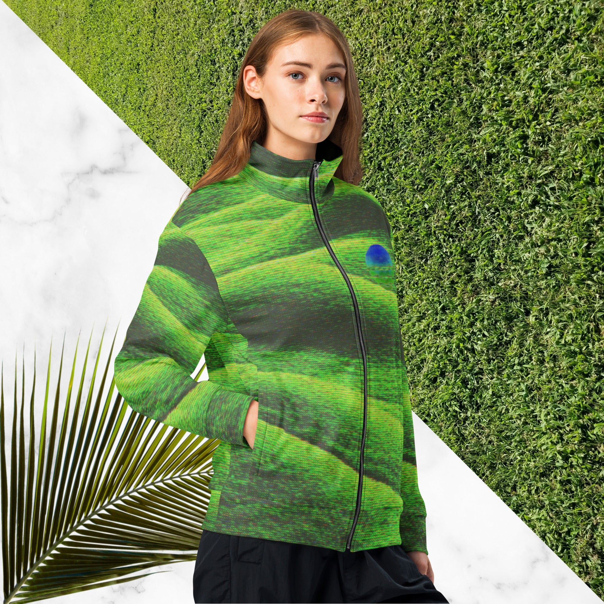 Primarily green and black full color all over print track jacket depicting grass covered green rolling hills and their shadows overlayed with detailed v h s and retro t v distortion with a green and blue Neon Pools vaporwave sun and waves emblem on the left chest