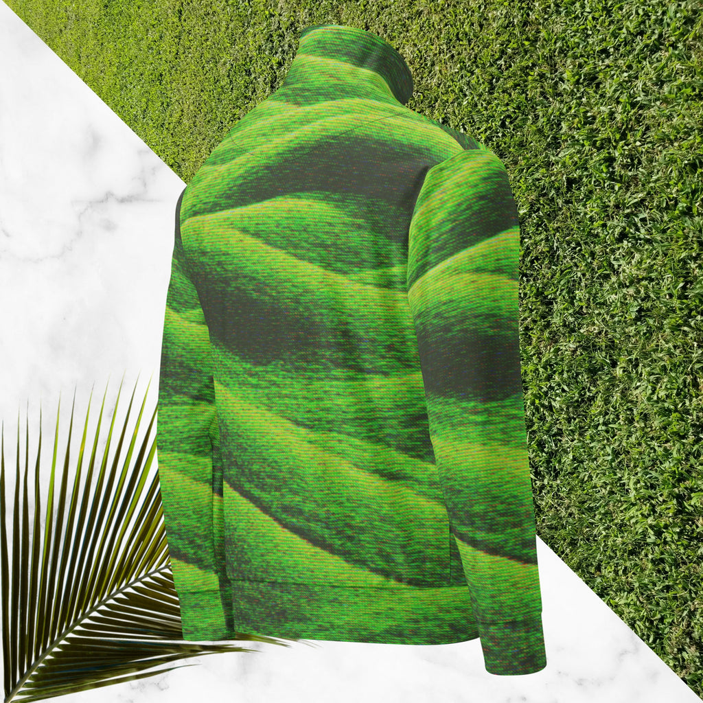 Primarily green and black full color all over print track jacket depicting grass covered green rolling hills and their shadows overlayed with detailed v h s and retro t v distortion with a green and blue Neon Pools vaporwave sun and waves emblem on the left chest