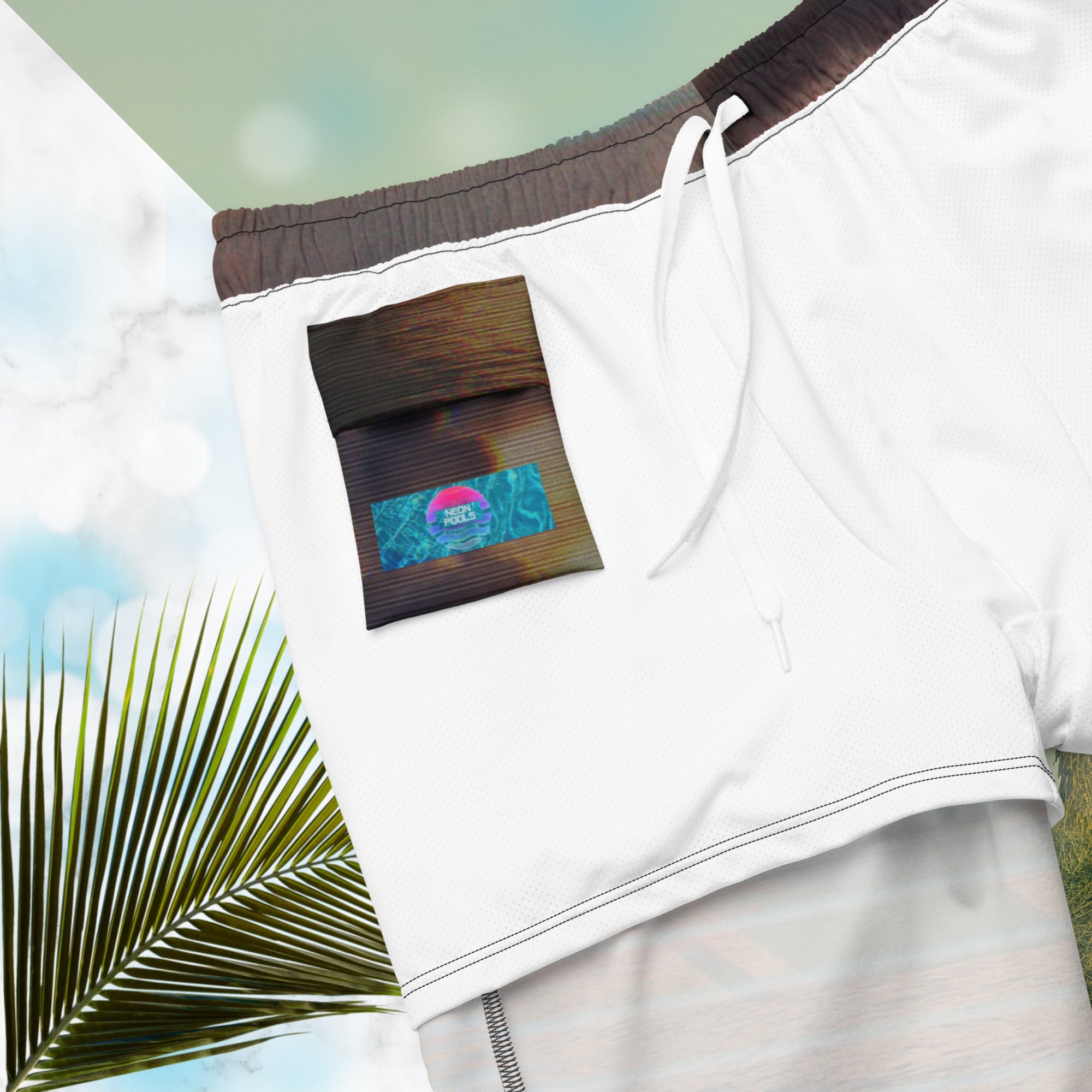 Closup of Neon Pools logo and insignia on inner pocket and inner liner on full color all over print swim trunks with retro ocean sunset with shimmering water photo overlayed with transparent stripes and graphic shapes in a 1980s memphis design style partial stripes and a transparent vaporwave broken sun in coral tone with detailed vhs distortion effects