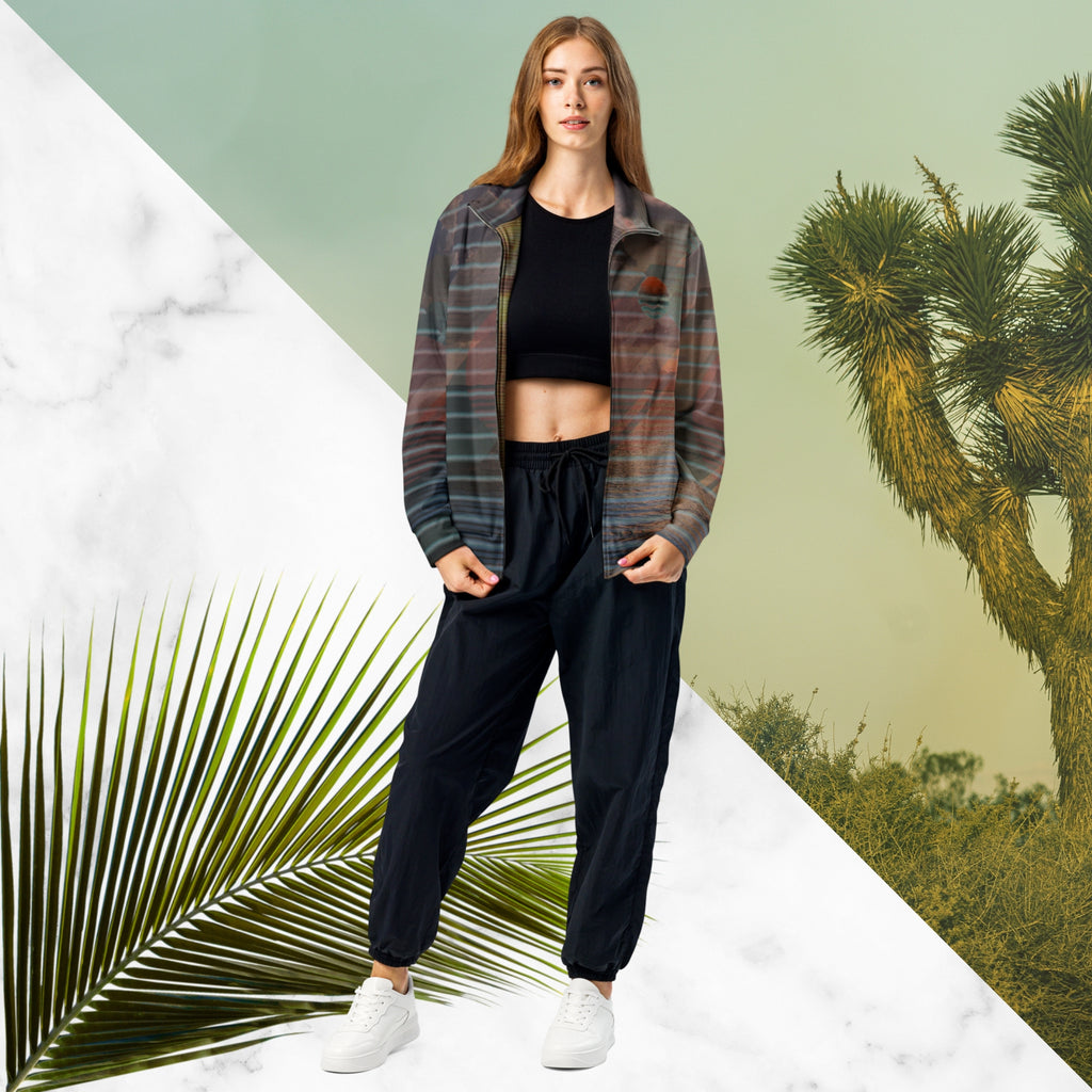 Full color all over print track jacket with retro ocean sunset with shimmering water photo overlayed with transparent stripes and graphic shapes in a 1980s memphis design style partial stripes and a transparent vaporwave broken sun in coral tone neon pools broken sun and waves logo emblem at left chest