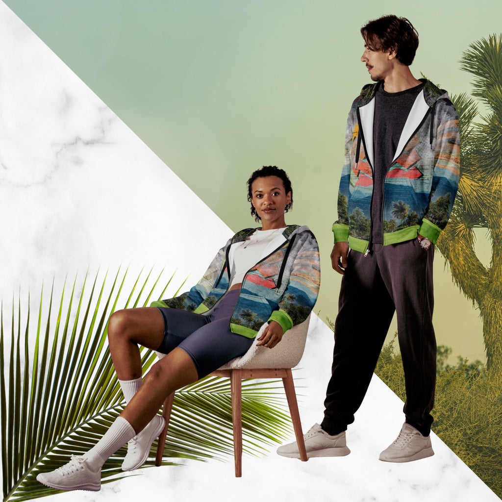 Colorful vaporwave and memphis design inspired all over print zip hoodie depicting a foreground of grass and palm trees with a backdrop of mountains more mountains and a sky filled with retro yellow orange salmon and red cascading bold zigzags tv scan lines turquoise dots and vaporwave broken sun on the back with clouds diagonal white stripes on right sleeve horizontal orange stripes on left sleeve
