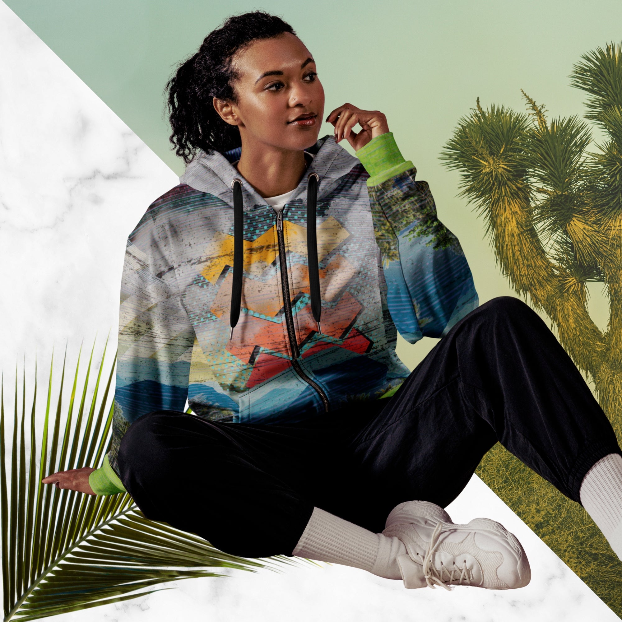 Colorful vaporwave and memphis design inspired all over print zip hoodie depicting a foreground of grass and palm trees with a backdrop of mountains more mountains and a sky filled with retro yellow orange salmon and red cascading bold zigzags tv scan lines turquoise dots and vaporwave broken sun on the back with clouds diagonal white stripes on right sleeve horizontal orange stripes on left sleeve