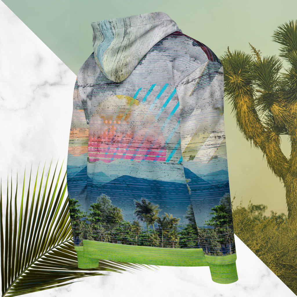 Colorful vaporwave and memphis design inspired all over print zip hoodie depicting a foreground of grass and palm trees with a backdrop of mountains more mountains and a sky filled with retro yellow orange salmon and red cascading bold zigzags tv scan lines turquoise dots and vaporwave broken sun on the back with clouds diagonal white stripes on right sleeve horizontal orange stripes on left sleeve
