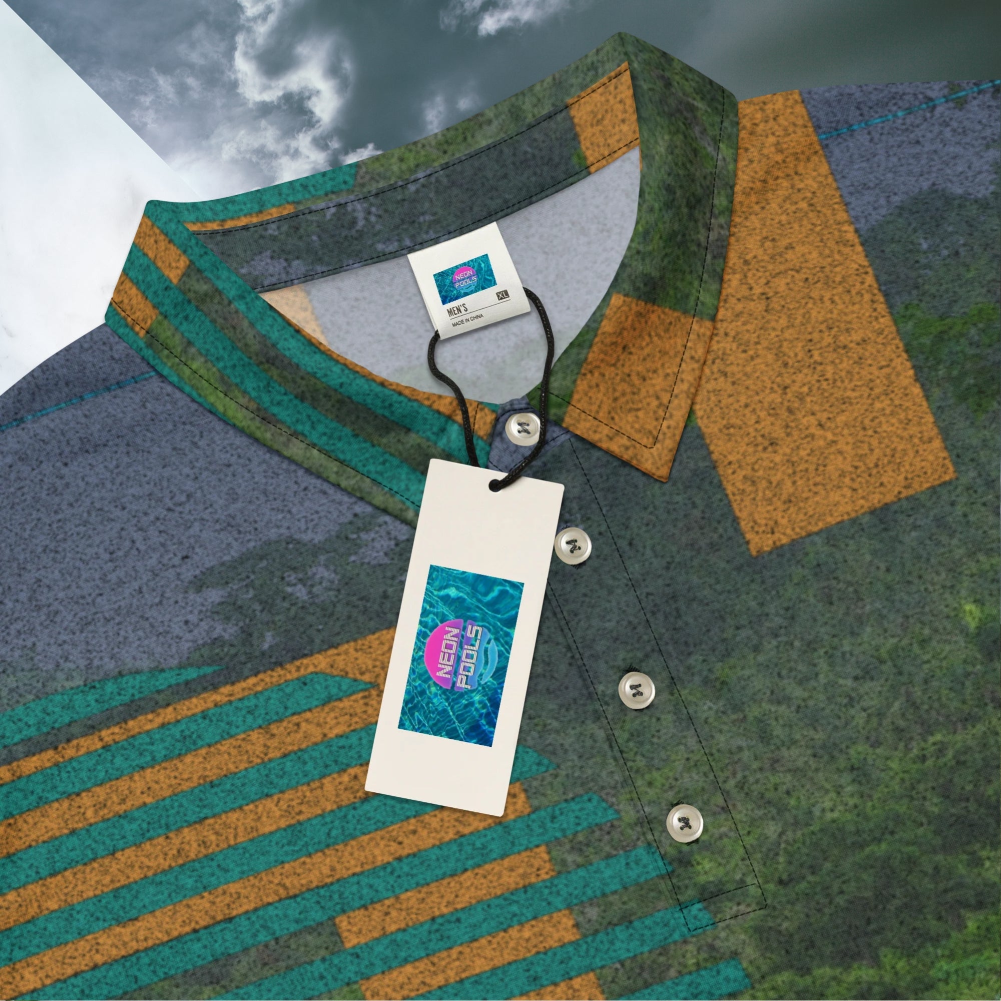 Closeup of collar inner label and Neon Pools logo retail tag on primarily green orange teal and misty blue shirt depicting a dense lush misty jungle overlayed and interlaced with 3d ferns monstera plants and bold solid orange abstract graphic shapes bold teal rounded modern stripes and a dark gray stormy sky at the top overlayed with retro inspired static similar to video degradation on an old tv set